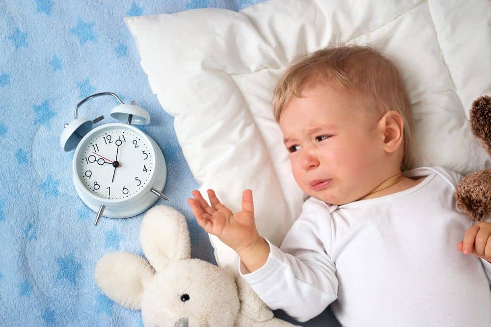 Elternteil begleitet ein Baby beim Einschlafen